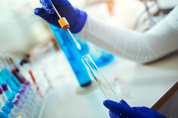 Female forensic technician collecting biological specimen in DNA